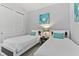 This bedroom features two twin beds with white bedding, a wall art, and a closet for storage at 7759 Westland Dr, Kissimmee, FL 34747