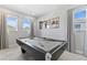 The billiards room features a gray pool table, neutral walls, and great natural light from two large windows at 7759 Westland Dr, Kissimmee, FL 34747