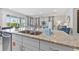 Bright kitchen with granite countertops, a stainless steel sink, and views to the living area and outside at 7759 Westland Dr, Kissimmee, FL 34747