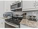 Close up of the kitchen with stainless steel oven, microwave, granite countertops, and subway tile backsplash at 7759 Westland Dr, Kissimmee, FL 34747