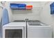 Laundry room with side by side washer and dryer units, wire shelving and ample storage capacity at 7759 Westland Dr, Kissimmee, FL 34747