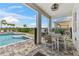 Covered patio next to a pristine pool, equipped with an outdoor dining area and grill at 7759 Westland Dr, Kissimmee, FL 34747
