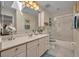 Well-lit bathroom featuring a vanity with a large mirror, and shower-tub combo with sliding glass doors at 796 Mcintyre Ave, Winter Park, FL 32789