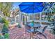 Charming brick patio features an outdoor dining set under a blue umbrella at 796 Mcintyre Ave, Winter Park, FL 32789