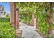 Charming walkway features brick columns, a pergola, lush greenery, and stone pavers, creating a tranquil outdoor space at 796 Mcintyre Ave, Winter Park, FL 32789