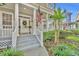 Attractive front porch featuring white columns, potted plants, and a decorative wreath on the front door at 821 Veranda Pl, Celebration, FL 34747