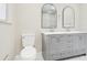 Modern bathroom featuring double sinks with gray cabinets and a glass-enclosed shower at 8506 Shady Glen Dr, Orlando, FL 32819