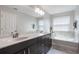 Bright bathroom with a double vanity, a soaking tub, and ample counter space at 8643 Coventry Park Way, Windermere, FL 34786