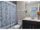 Bathroom with a single sink vanity, toilet, and tub with a blue patterned shower curtain at 8643 Coventry Park Way, Windermere, FL 34786