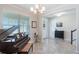 Elegant entryway with neutral tones, grand piano, and modern chandelier lighting the tiled space at 8643 Coventry Park Way, Windermere, FL 34786