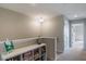 Light-filled upstairs hallway featuring a built-in shelf displaying various books and games at 8643 Coventry Park Way, Windermere, FL 34786