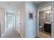 Hallway with neutral paint and carpet, white doors and trim, and access to a bathroom at 8643 Coventry Park Way, Windermere, FL 34786