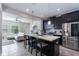 Open-concept kitchen with a quartz island, stainless steel appliances, and seating adjacent to living room at 8643 Coventry Park Way, Windermere, FL 34786