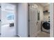 Bright laundry room with a front load washer and dryer and a view into a bedroom with tray ceilings at 8643 Coventry Park Way, Windermere, FL 34786