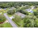 A high angle aerial view of a home with pool in wooded community surrounded by green lawns at 89 Pine Forest Ln, Haines City, FL 33844