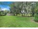 Large, well-maintained backyard with a shed and mature trees creating a private outdoor space at 89 Pine Forest Ln, Haines City, FL 33844