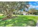 Expansive green lawn surrounds this charming single-story home with mature trees at 89 Pine Forest Ln, Haines City, FL 33844