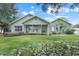 Charming single-story home with lush landscaping, covered porch, and updated color scheme at 89 Pine Forest Ln, Haines City, FL 33844