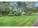 Lush green lawn surrounded by mature trees and manicured hedges at 89 Pine Forest Ln, Haines City, FL 33844