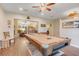 Open-concept game room features a pool table and access to other living spaces in a warmly lit home at 89 Pine Forest Ln, Haines City, FL 33844