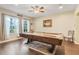 Spacious game room with pool table, hardwood floors, and natural light from the windows at 89 Pine Forest Ln, Haines City, FL 33844
