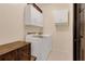 Laundry room featuring a washer, dryer, upper cabinets and a dark wood storage chest at 89 Pine Forest Ln, Haines City, FL 33844