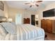 This main bedroom features a large bed, ceiling fan, ensuite bathroom, and wood floors at 89 Pine Forest Ln, Haines City, FL 33844
