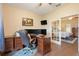Bright office with a large desk, multiple monitors, and glass doors opening to the main bedroom at 89 Pine Forest Ln, Haines City, FL 33844