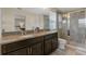 Bathroom featuring a double vanity, granite countertops, walk-in shower with glass doors, and neutral tile floors at 9433 Randal Park Blvd, Orlando, FL 32832