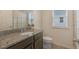 Bathroom with granite counters, dark wood cabinets, modern sink and a stylish mirror at 9433 Randal Park Blvd, Orlando, FL 32832