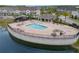 Aerial view of a community pool surrounded by lounge chairs and cabana area, near a pond at 9433 Randal Park Blvd, Orlando, FL 32832