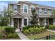 Stylish two-story townhome featuring a welcoming front porch and tidy, green landscaping at 9433 Randal Park Blvd, Orlando, FL 32832