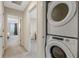 Upstairs hallway featuring laundry closet and open doorways to nearby bedrooms at 9433 Randal Park Blvd, Orlando, FL 32832