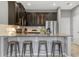 Kitchen with breakfast bar including granite countertops, seating for four, stainless appliances, and dark cabinets at 9433 Randal Park Blvd, Orlando, FL 32832