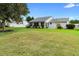 Expansive backyard showing the home's rear exterior and lush green lawn at 25929 Newcombe Cir, Leesburg, FL 34748