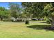Backyard lawn view of community lake featuring mature shade trees at 25929 Newcombe Cir, Leesburg, FL 34748