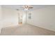 Bright bedroom featuring neutral carpet, ceiling fan, and an adjacent bathroom at 25929 Newcombe Cir, Leesburg, FL 34748