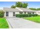 Well-maintained single-story home with charming curb appeal and a decorative driveway at 25929 Newcombe Cir, Leesburg, FL 34748
