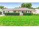 Charming single-story home with a well-manicured lawn, neat shrubbery, and a covered front porch at 25929 Newcombe Cir, Leesburg, FL 34748