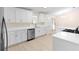 Modern kitchen featuring white cabinets, stainless steel appliances, and an open design at 25929 Newcombe Cir, Leesburg, FL 34748