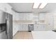 Bright kitchen featuring white cabinets, stainless steel appliances, and a modern skylight at 25929 Newcombe Cir, Leesburg, FL 34748
