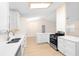 Open kitchen featuring white cabinets, stainless steel appliances and a view to the dining area at 25929 Newcombe Cir, Leesburg, FL 34748