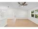 Spacious living room with light wood flooring, vaulted ceiling, and natural light at 25929 Newcombe Cir, Leesburg, FL 34748