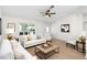Bright living room features wood floors, large window, ceiling fan, and neutral decor at 25929 Newcombe Cir, Leesburg, FL 34748