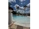 Beautiful community pool featuring comfortable seating, landscaping, and blue skies with puffy clouds overhead at 3045 Yellow Lantana Ln, Kissimmee, FL 34747