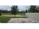 View of the home's backyard including a small patio and green space beyond the fence line at 669 Big Pine Ave, Minneola, FL 34715