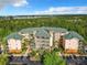 Aerial view of condo complex featuring a lush green landscape and ample parking at 9051 Treasure Trove Ln # 405, Kissimmee, FL 34747
