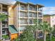 Exterior view of a condo building with multiple balconies and lush landscaping at 9051 Treasure Trove Ln # 405, Kissimmee, FL 34747