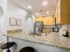 Well-lit kitchen features stainless appliances, granite counters, and a breakfast bar with seating at 9051 Treasure Trove Ln # 405, Kissimmee, FL 34747