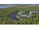 Scenic aerial view of condos nestled by a lake surrounded by lush greenery at 9061 Treasure Trove Ln # 104, Kissimmee, FL 34747